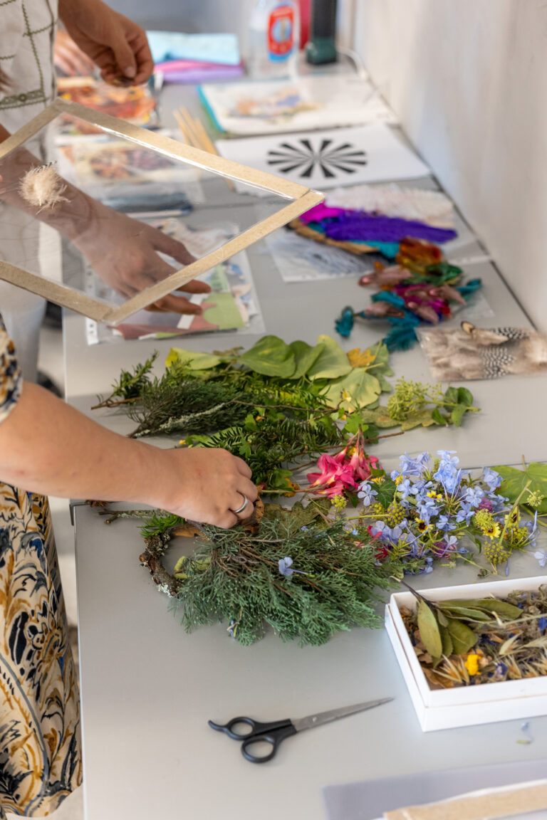 Mãos a criar arte botânica com materiais naturais