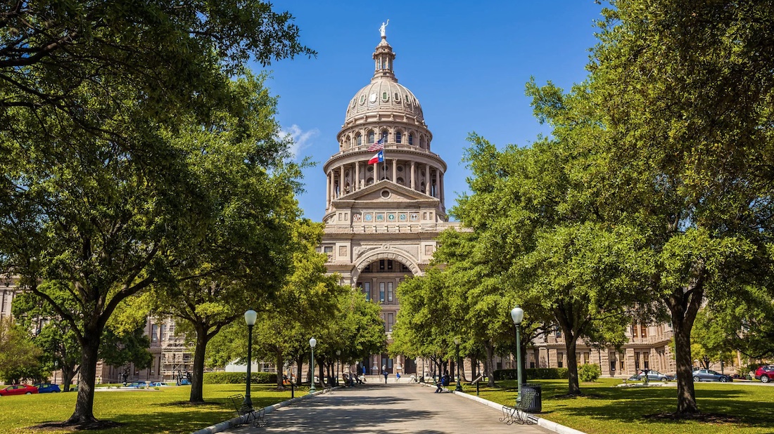 Texas State Capitol building framed by trees