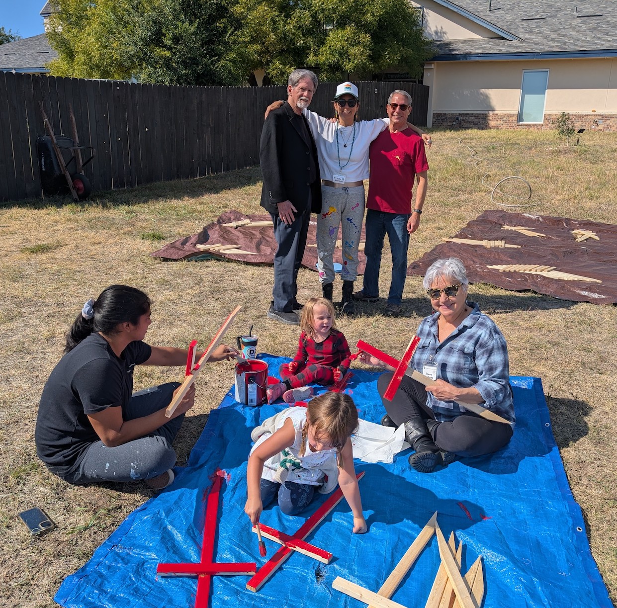Pastor Jim Rigby and church members painting crosses in the yard