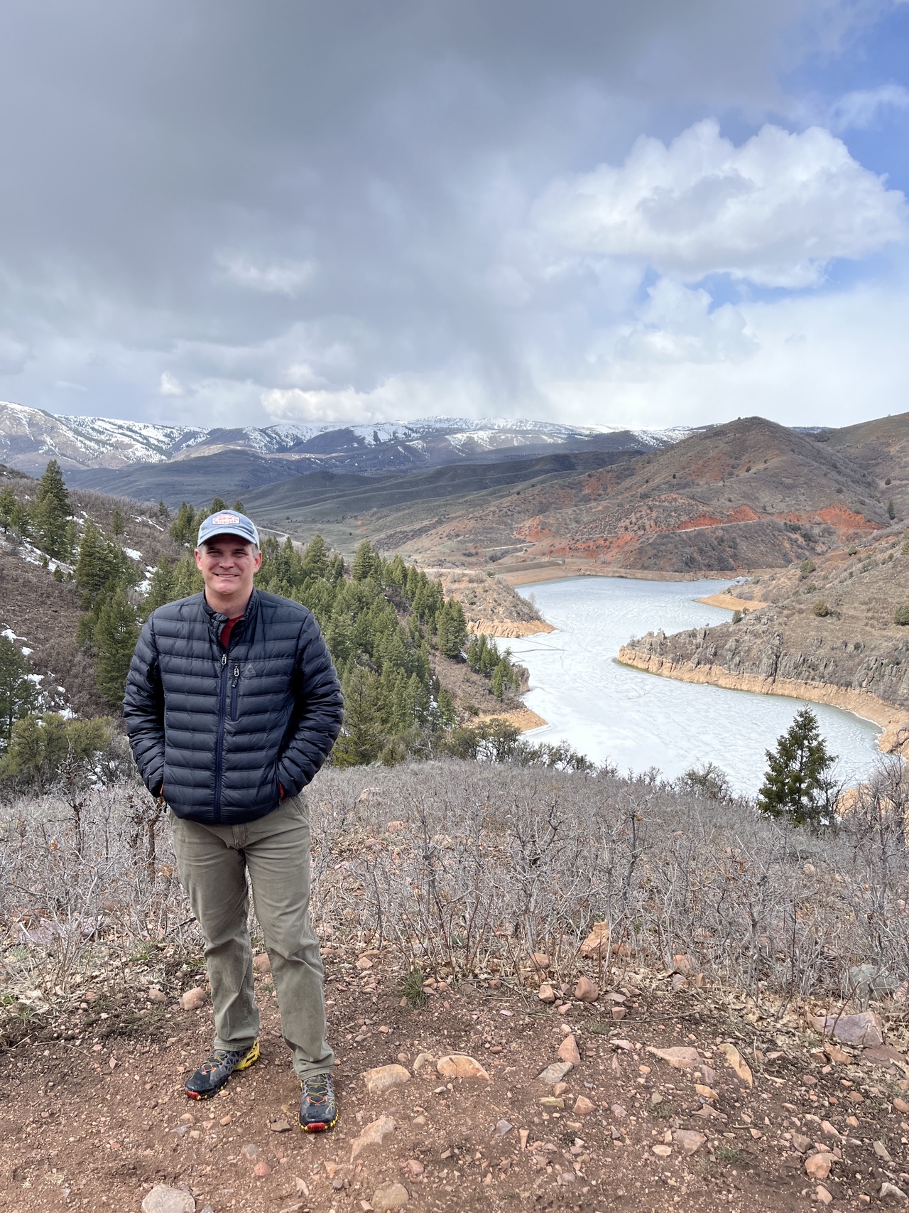 Dr. Avery Collins outdoors by a river with mountain backdrop